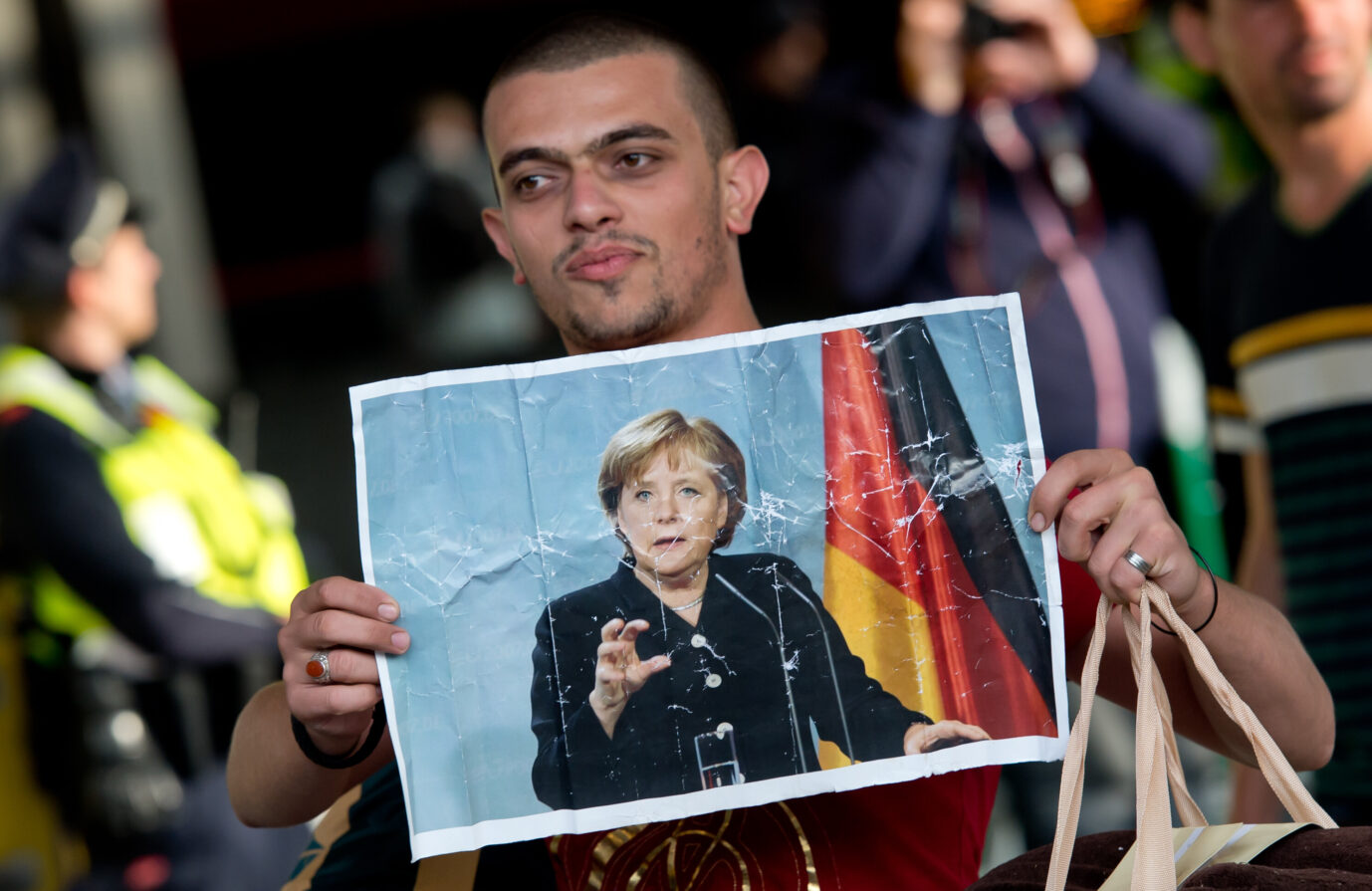 5. September 2015: Ein Asylsuchender am Münchner Hauptbahnhof hält ein Foto der Bundeskanzlerin Angela Merkel (CDU). (Themenbild)