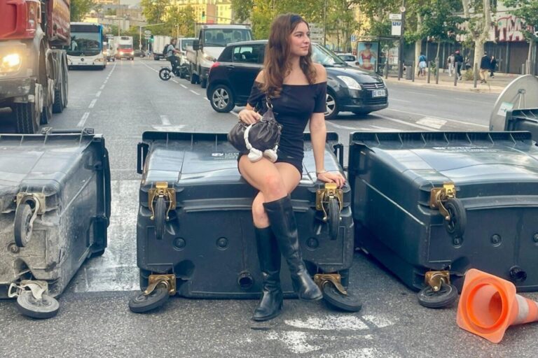 Eine junge Frau sitzt in Marseille auf einer umgekippten Mülltonne. Frankreichs Präsident Macron ist angezählt.