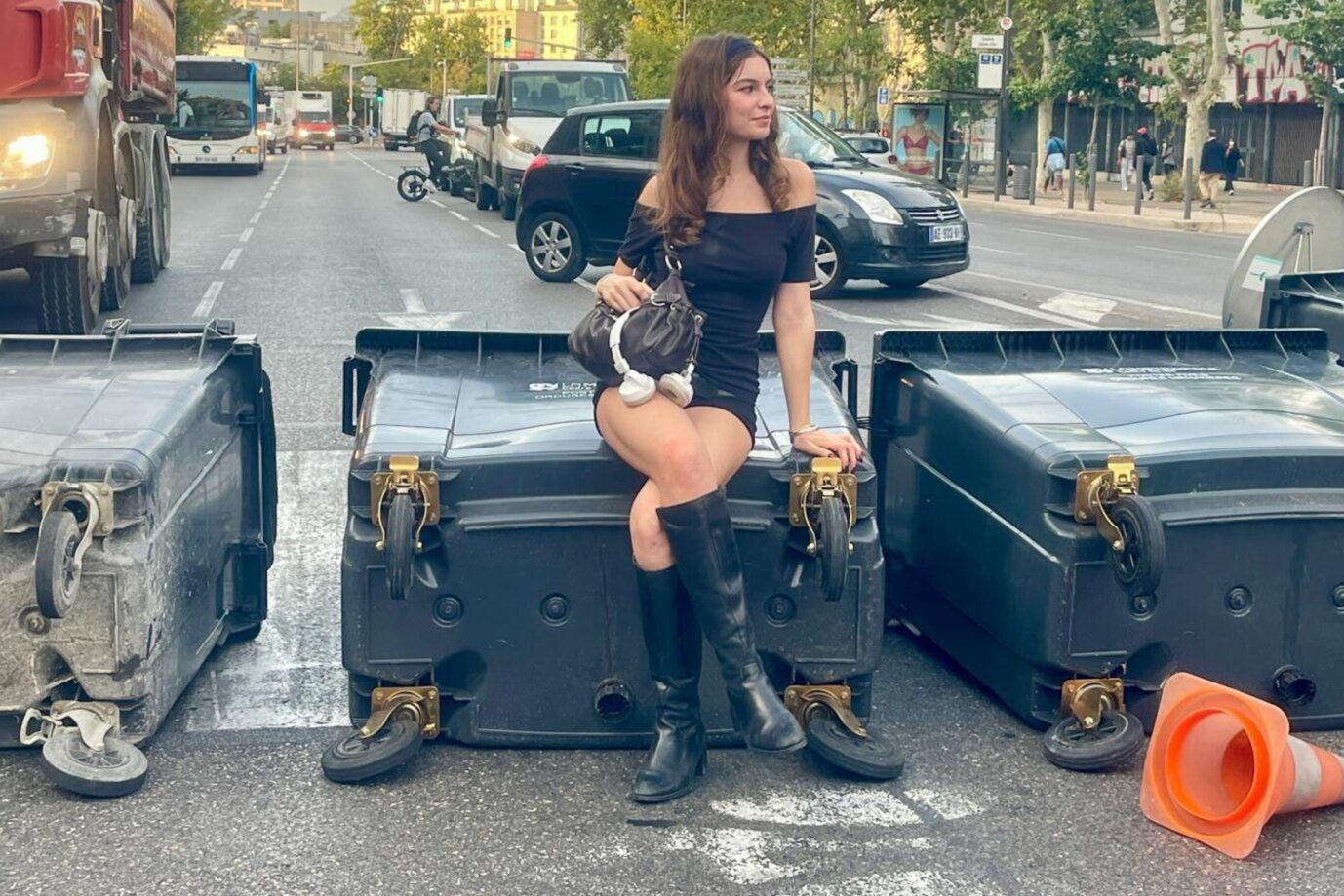 Eine junge Frau sitzt in Marseille auf einer umgekippten Mülltonne. Frankreichs Präsident Macron ist angezählt.
