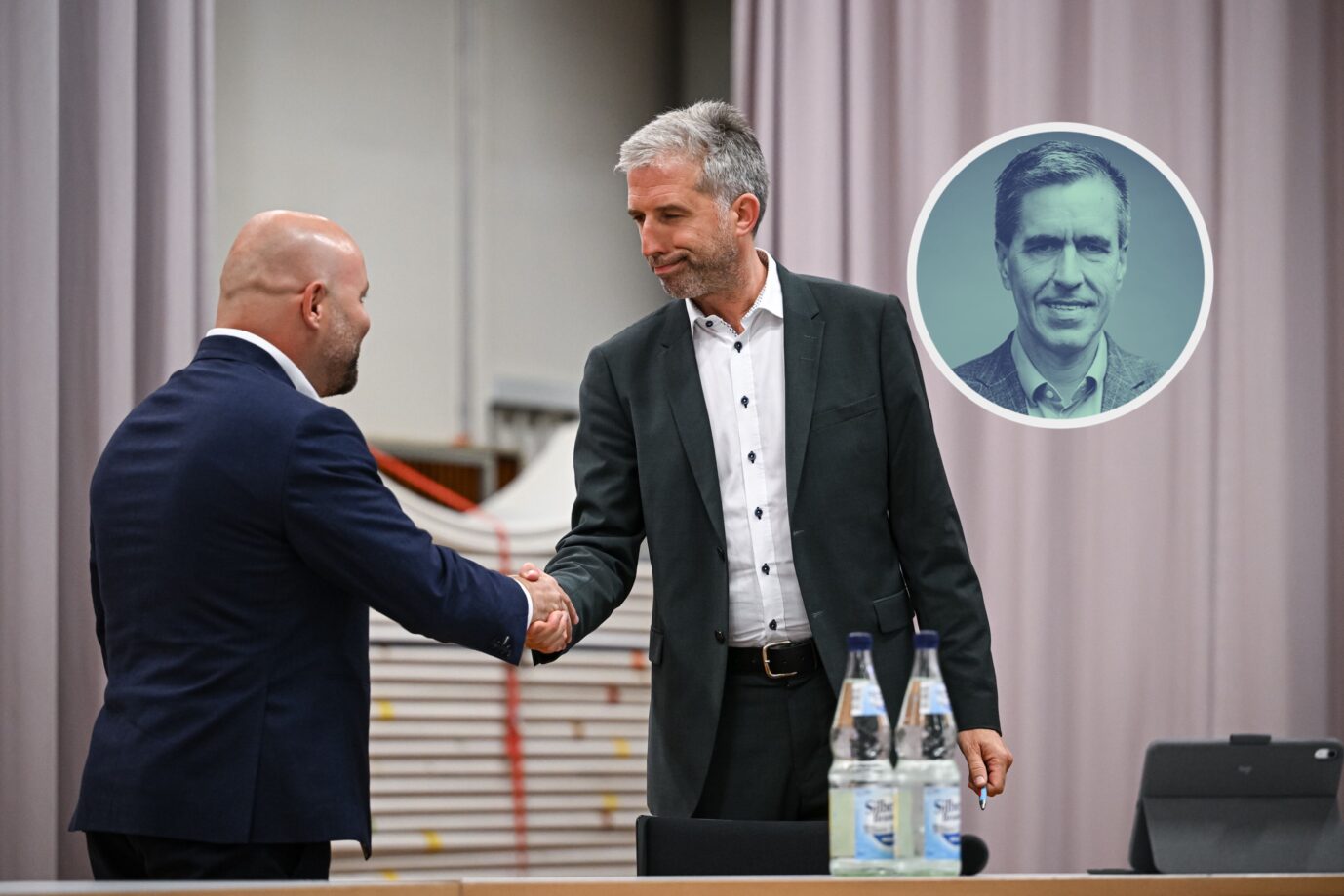 Tübingens Oberbürgermeister Boris Palmer (rechts) und der AfD-Landesvorsitzende Baden-Württemberg, Markus Frohnmaier (links), geben sich in der Hermann-Hepper-Halle bei einem Streitgespräch die Hand. Im Hintergrund ist im Rahmen ein Porträt von JF-Chefredakteur Dieter Stein eingeblendet. Händedruck in Tübingen: Boris Palmer und AfD-Spitzenkandidat Markus Frohnmaier im Streitgespräch. Foto: picture alliance / Pressefoto Ulmer | Markus Ulmer