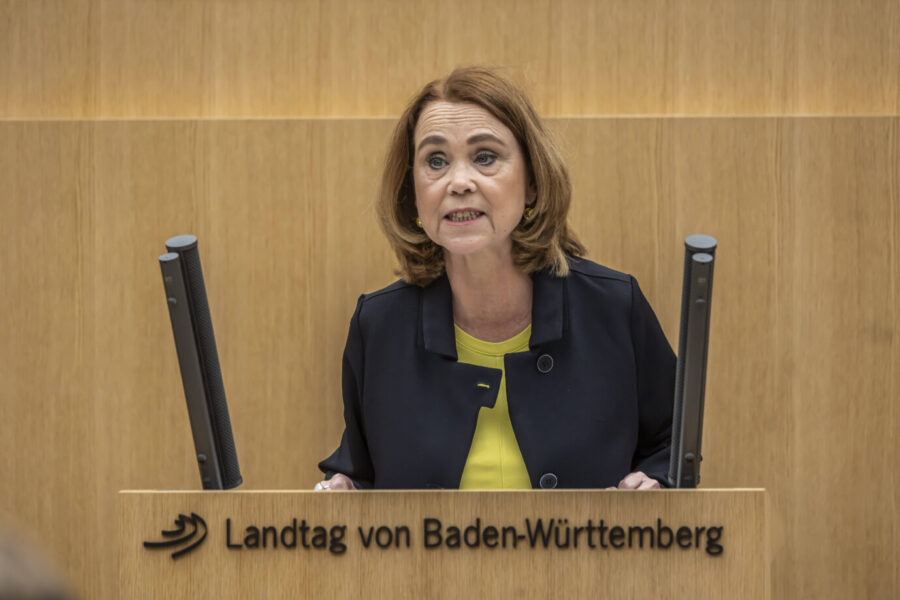 Die baden-württembergische Wissenschaftsmnisterin Petra Olschowski (Grüne) steht vor einem Rednerpult und schaut extrem irre – vielleicht denkt sie gerade an die AfD