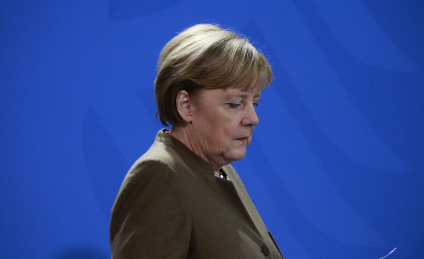 Die ehemalige Bundeskanzlerin Angela Merkel (CDU) steht vor einer blauen Wand und schaut nachdenklich zu Boden – erlebt sie etwa einen Moment des Zweifelns angesichts zehn Jahre "Wir schaffen das"?