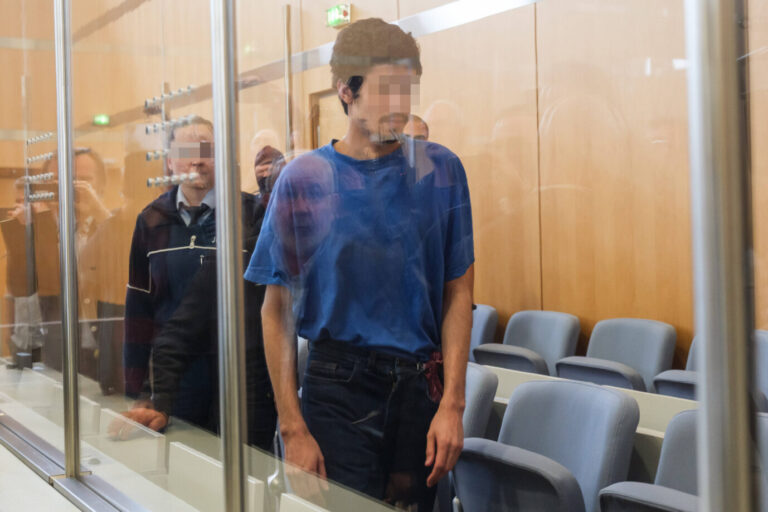 Der islamistische Messerattentäter von Solingen, Issa al H. läuft in einem blauen Hemd durch den Gerichtssaal – laut psychiatrischem Gutachten ist er dumm aber schuldfähig