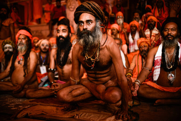 Ein indischer hinduistischer Sadhu sitzt in einer Yogapose in einem Zelt und schaut mit weit aufgerissenen Augen in die Ferne – Symbolbild für die indische Philosophie