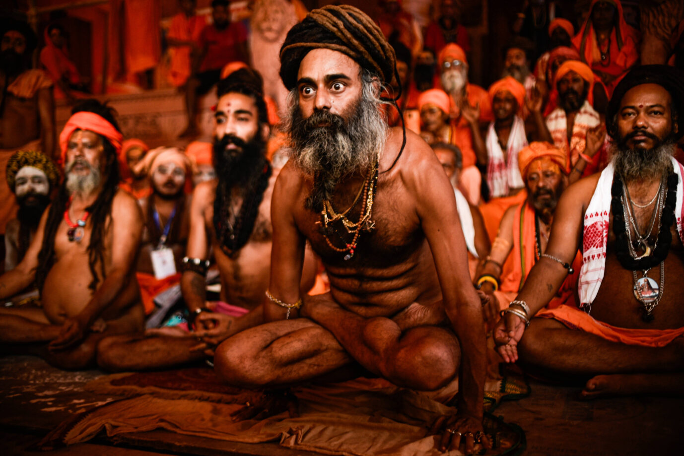 Ein indischer hinduistischer Sadhu sitzt in einer Yogapose in einem Zelt und schaut mit weit aufgerissenen Augen in die Ferne – Symbolbild für die indische Philosophie