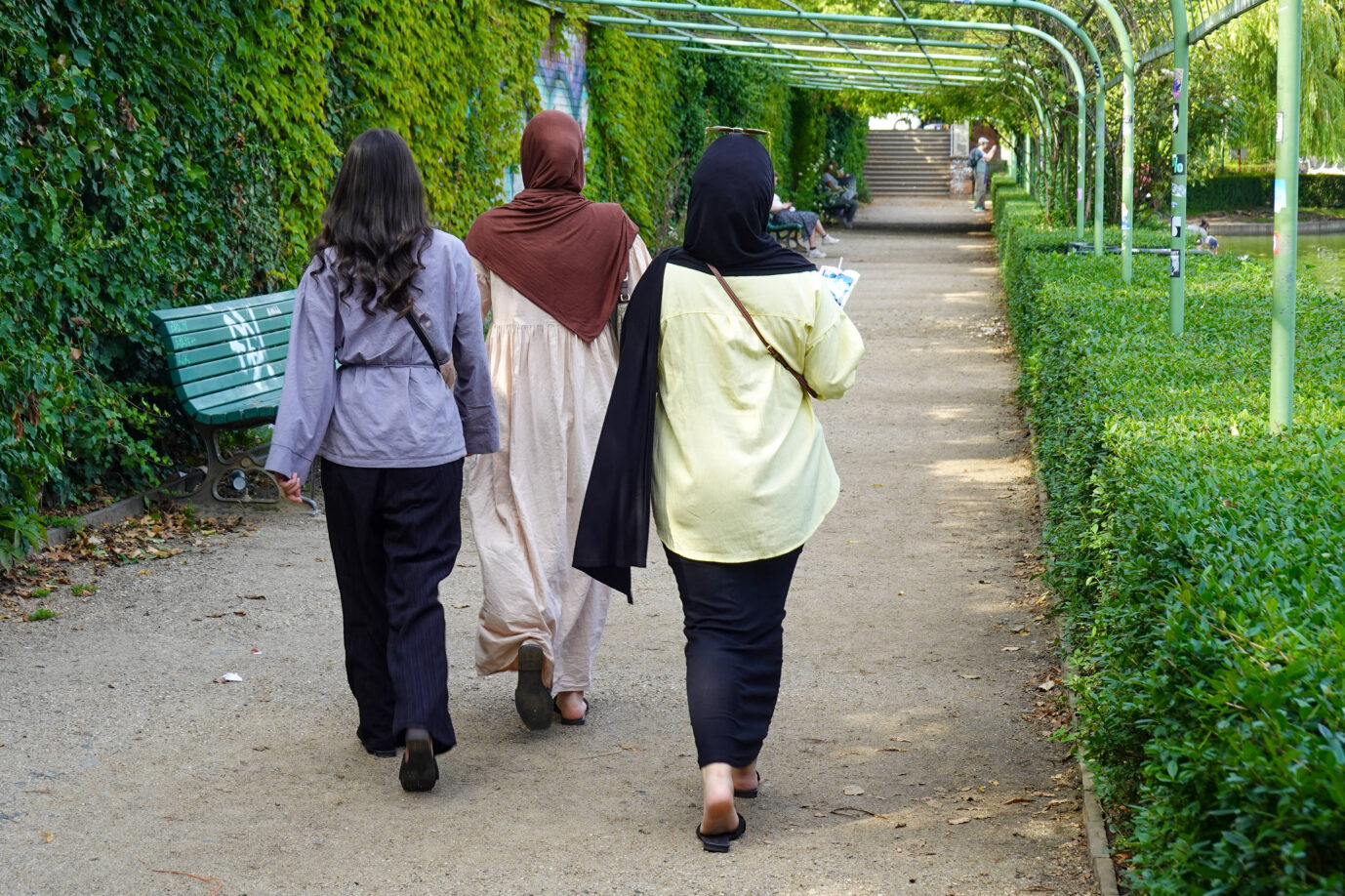 Drei migrantische Frauen, zwei davon mit Kopftuch, laufen durch einen Berliner Park – in der Generation der Wiederverinigung, also den heutigen 35jährigen, ist der Anteil von Migranten hoch