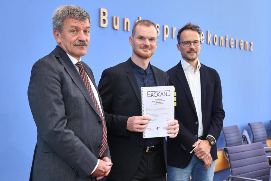 Drei Männer stehen nebeneinander, einer hält ein Dokument mit der Aufschrift „EKOCAN“ in den Händen. In Berlin wurde am 29. September 2025 der erste Zwischenbericht zur Evaluation des Konsumcannabisgesetzes vorgestellt. Vorstellung des ersten Zwischenberichtes zur Cannabislegalisierung: Die Forscher Jörg Kinzig, Jakob Manthey und Daniel Kotz präsentieren EKOCAN in Berlin. Foto: IMAGO / dts Nachrichtenagentur