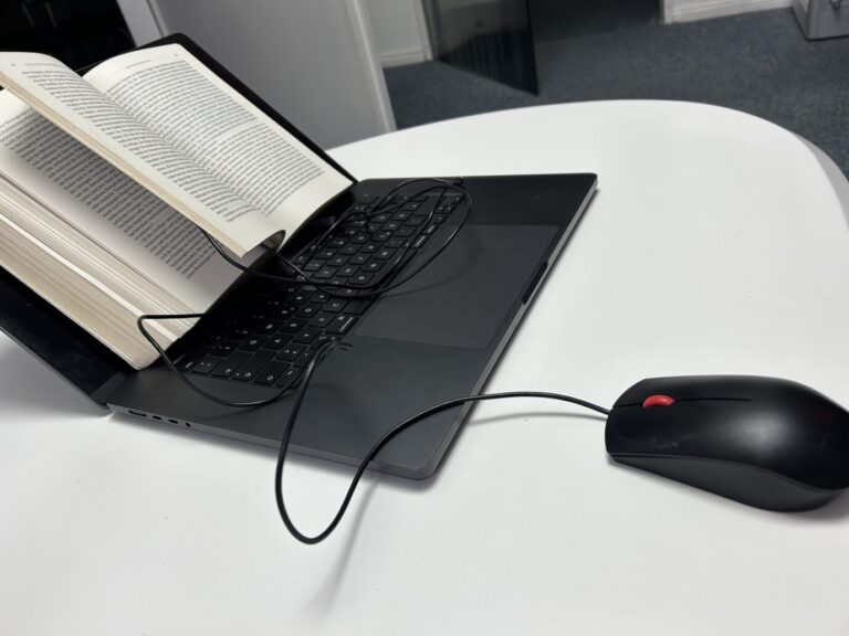 Ein Buch liegt auf einem Laptop – Symbolbild für ein rechten Theorie-Milieu im Netz, etwa auf Youtube und Substack