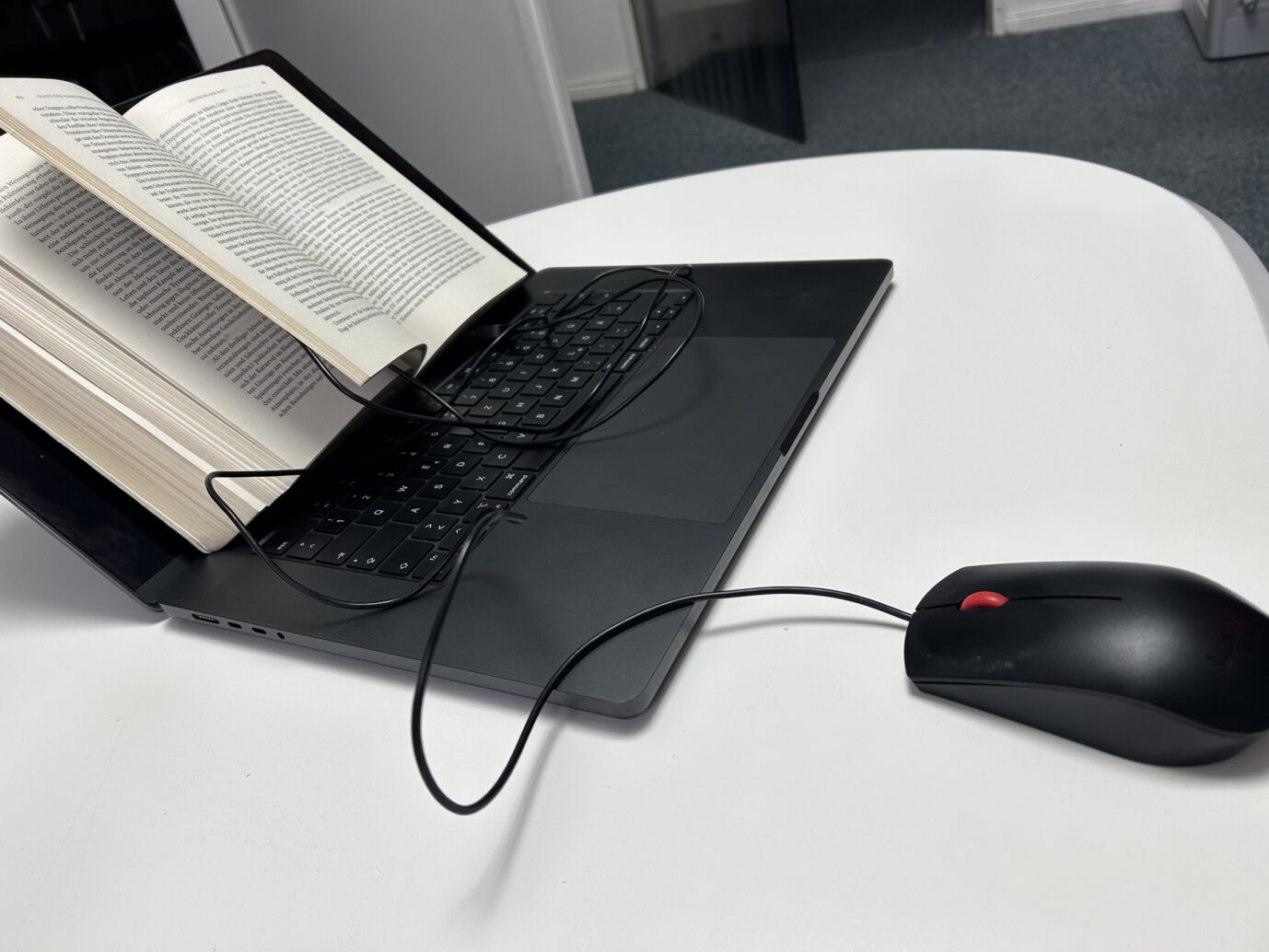 Ein Buch liegt auf einem Laptop – Symbolbild für ein rechten Theorie-Milieu im Netz, etwa auf Youtube und Substack