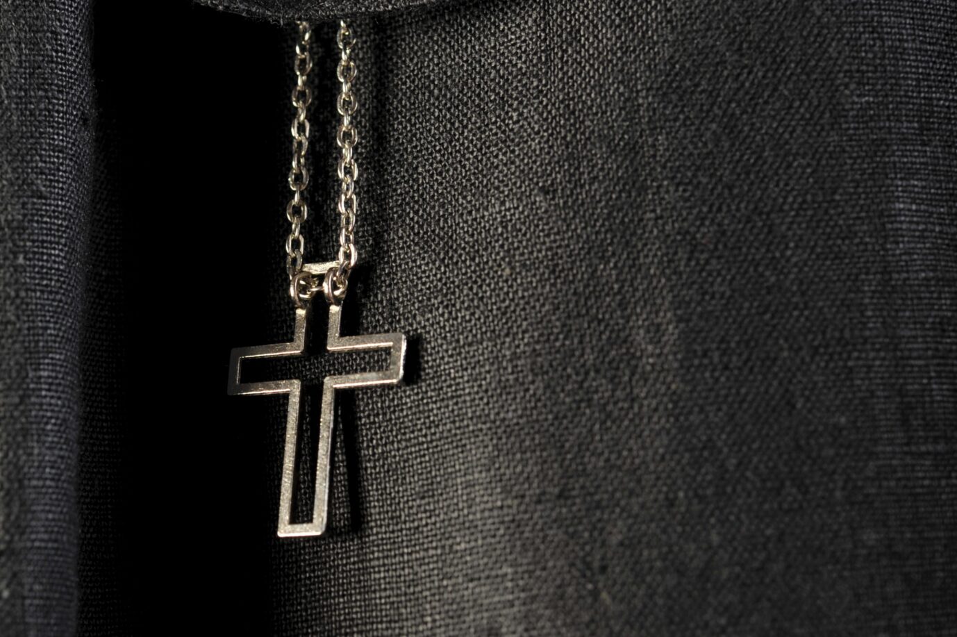 Kette mit Kreuzanhänger hängt auf schwarzer Jacke. Kette mit Kreuzhänger: Unter den jüngeren Deutschen glaubt eine Mehrheit an Gott. Foto: picture alliance / imageBROKER | Ulrich Niehoff