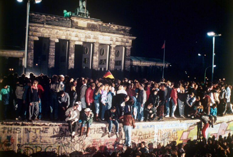 Jubelnde Menschen auf der Berliner Mauer vor dem Brandenburger Tor am 09.11.1989. Nach der Öffnung eines Teils der deutsch-deutschen Grenzübergänge in der Nacht vom 9. auf den 10. November 1989 reisten Millionen DDR-Bürger für einen kurzen Besuch in den Westen. In der Folge wurde die innerdeutsche Grenze abgebaut, seit dem 3. Oktober 1990 ist Deutschland wieder vereint.