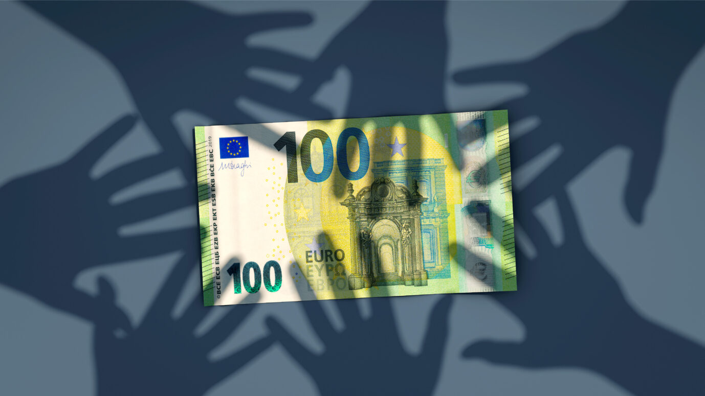 Ein Hunderteuro-Schein liegt auf einem blauen Untergrund, umgeben von Schatten ausgestreckter Hände. Das Bild symbolisiert mutmaßlichen Sozialmißbrauch durch bezahlte Vaterschaftsanerkennungen in Dortmund. Hunderteuro-Schein mit Schatten von Händen: In Dortmund stehen Vaterschaften unter Betrugsverdacht. Foto: picture alliance / Zoonar | DesignIt