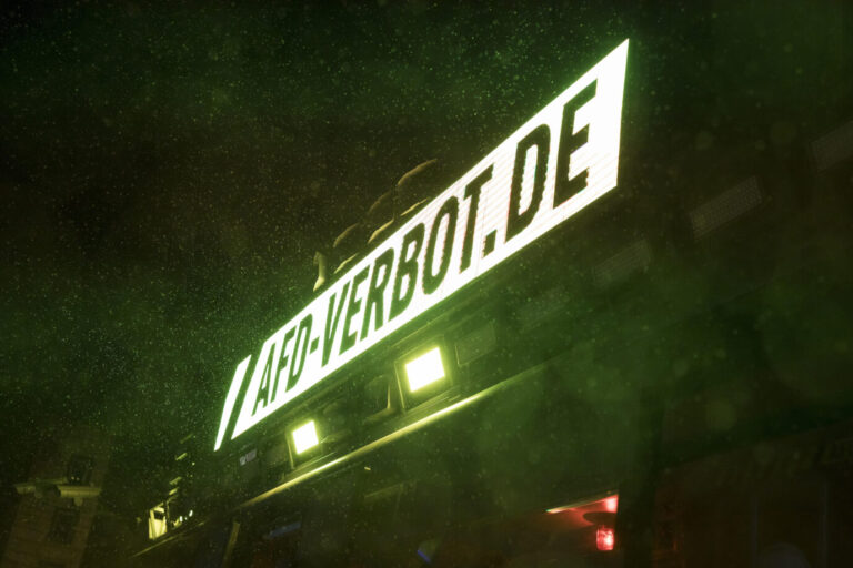 Leuchtanzeige mit der Aufschrift „afd-verbot.de“ auf einem Fahrzeug bei Nacht, grünlich ausgeleuchtet. Gezeigt wurde die Szene bei einer Aktion des Zentrums für Politische Schönheit vor dem Brandenburger Tor zur Grimme-prämierten Kampagne gegen die AfD. Laufschrift auf dem umgebauten AfD-Gegner-Bus in Berlin: Für die Aktion „AfD-Verbot“ erhielt das Zentrum für Politische Schönheit den Publikumspreis des Grimme-Instituts. Foto: picture alliance / PIC ONE | Ben Kriemann