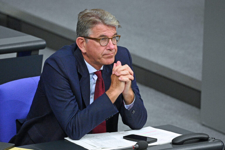 Ein Mann im blauen Anzug und roter Krawatte sitzt mit gefalteten Händen im Bundestag. Es ist Kulturstaatsminister Wolfram Weimer, dessen Portal The European wegen ungekennzeichneter Textübernahmen in der Kritik steht. Wolfram Weimer im Bundestag: Der Kulturstaatsminister steht wegen seines Verlags The European weiter in der Kritik. Foto: picture alliance/dpa | Helena Dolderer