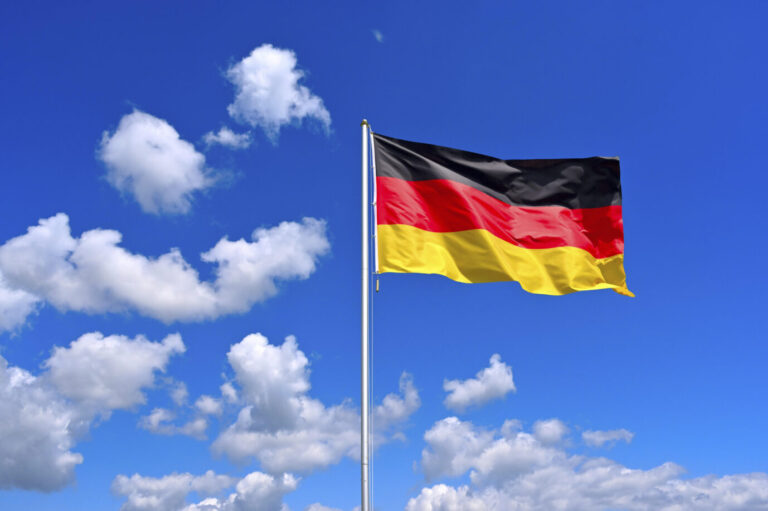 Vor einem blauen Himmel flattert eine Deutschlandfahne – in Hilchenbach haben Unbekannte ganz ähnliche Fahnen aufgehängt, weswegen nun die Polizei ermittelt