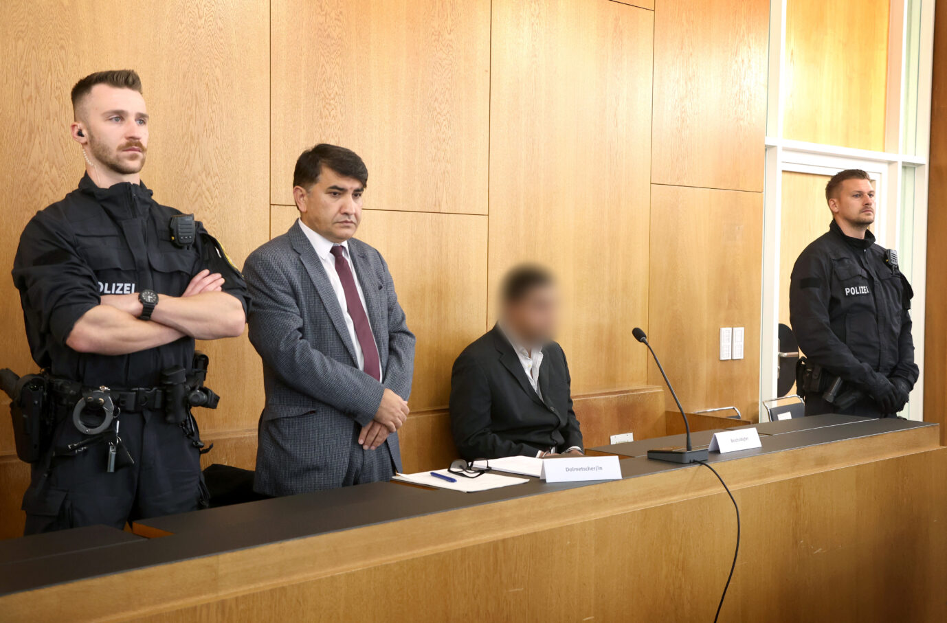 Ein Beschuldigter (2.v.r) sitzt im Gerichtssaal des Landgerichtes Aschaffenburg neben einem Dolmetscher (2.v.l). Der Afghane soll am 22. Januar einen 2-jährigen Jungen und einen 41-Jährigen mit einem Messer getötet haben. Drei Menschen wurden schwer verletzt. Ein Psychiater hatte dem Flüchtling nach der Gewalttat eine psychische Erkrankung attestiert. Die Staatsanwaltschaft wirft dem 28-Jährigen Mord, versuchter Mord, Totschlag, versuchter Totschlag, Bedrohung sowie diverse Körperverletzungsdelikte vor (Angeklagter darf auf Anordnung des Gerichts nicht zu erkennen sein).