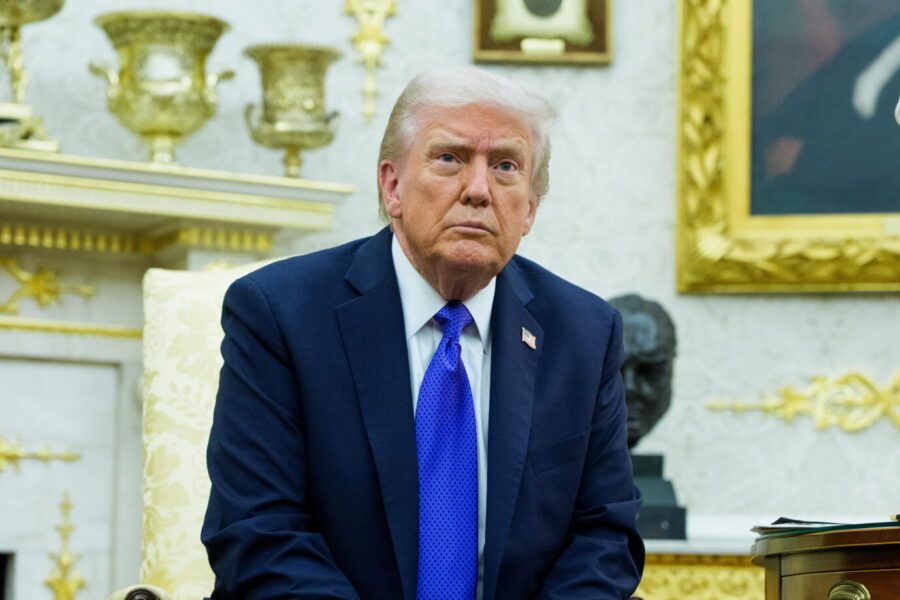 US-Präsident Donald Trump sitzt in einem Sessel im Oval Office, trägt einen dunklen Anzug und eine blaue Krawatte; im Hintergrund goldene Dekorationen und ein Porträt. Kontext: Urteil des Landgerichts Bonn über politische Tendenzen der US-Regierung unter Trump. Donald Trump im Oval Office: Das Landgericht Bonn bezeichnete seine Regierung als „offen rechtsextremistisch-populistisch“. Foto: picture alliance / Sipa USA | Sipa USA
