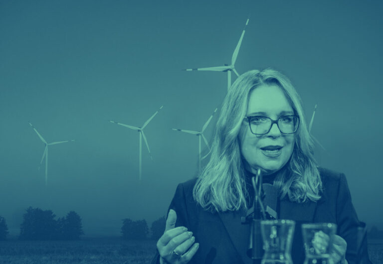 Vorne ist die Die Wirtschaftswissenschaftlerin Claudia Kemfert zu sehen, im Hintergrund drehen sich Windräder, symbolisch für die Energiewende stehend