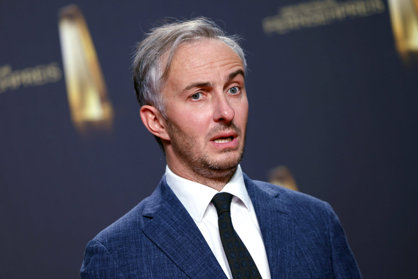 Der ZDF-Moderator Jan Böhmermann trägt Anzug und Krawatte und schaut dämlich in die Kamera