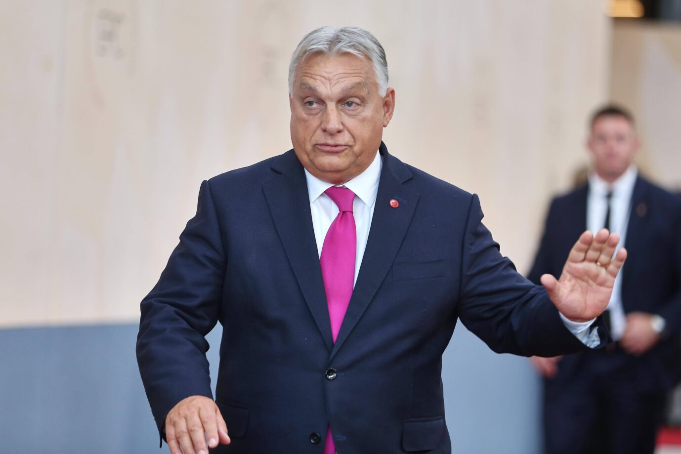 Der ungarische Ministerpräsident Viktor Orbán trägt Anzug und Krawatte und macht eine abwehrende Handbewegung