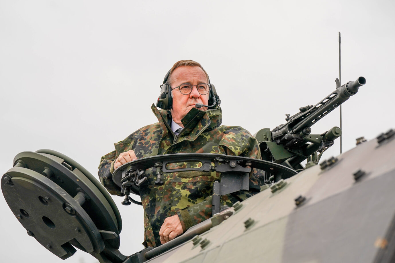Ein Mann in Tarnuniform und mit Headset steht aus der Luke eines Schützenpanzers und blickt zur Seite. Der Panzer ist grau-grün getarnt und mit einem Maschinengewehr ausgerüstet. Aufnahme während einer Bundeswehrübung, bei der Verteidigungsminister Boris Pistorius die Truppe inspiziert. Das Bild steht im Kontext der sicherheitspolitischen Neuausrichtung Deutschlands und der militärischen Stärkung im Zuge der Zeitenwende. Bundesverteidigungsminister Boris Pistorius während einer Bundeswehrübung auf einem Schützenpanzer Schwarz-Rot einigt sich auf eine Reaktivierung der Wehrpflicht. Foto: IMAGO / STEINSIEK.CH