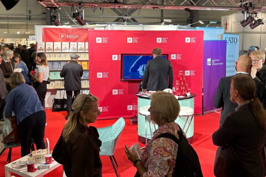 Am Stand der Jungen Freiheit sieht man einen roten Teppich, einen weißen Tisch und ein rotes Banner - es ist Seitenwechsel Buchmesse