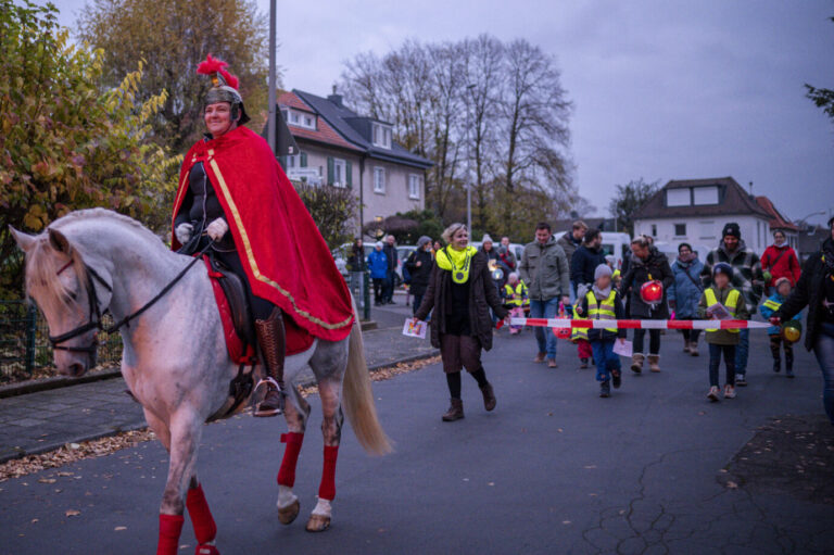 Kinder nehmen mit Laternen am Sankt Martins-Umzug teil.