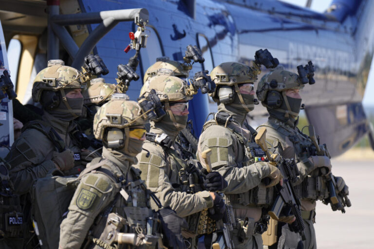 Mehrere schwerbewaffnete Polizisten der GSG 9 stehen in Einsatzkleidung vor einem Hubschrauber in St. Augustin; Symbolbild für den Zugriff der Spezialeinheit bei der Festnahme des Verdächtigen Martin S. in Dortmund. Mitglieder der GSG 9 vor einem Hubschrauber: Die Spezialeinheit war an der Festnahme im Auftrag der Generalbundesanwaltschaft von Martin S. in Dortmund beteiligt. Foto: picture alliance / Flashpic | Jens Krick