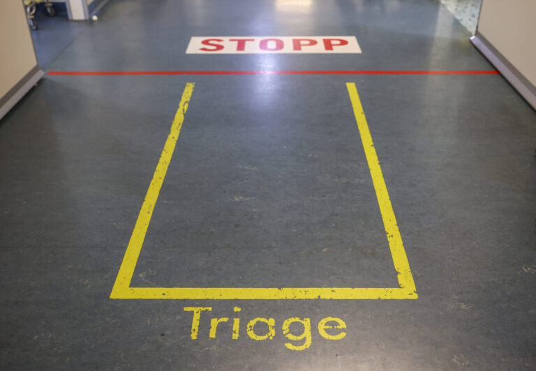 Eine Markierung und das Wort „Triage“ sind im Eingangsbereich der Notaufnahme der Leipziger Uniklinik zu sehen. Hier werden ankommende Patienten auf Corona getestet und je nach Schwere der Verletzung auf die weiteren Räume verteilt. Die Deutsche Gesellschaft für Unfallchirurgie feiert ihr 100-jähriges Bestehen. Dazu ist am Freitag an ihrem Gründungsort in Leipzig ein Festakt mit Gästen aus Medizin, Wissenschaft und Politik geplant. Markierung in der Leipziger Uniklinik: Das Bundesverfassungsgericht kippt die Triage-Regeln des Bundes als verfassungswidrig. Foto: picture alliance/dpa | Jan Woitas