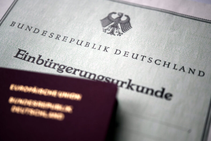 Ein deutscher Reisepaß liegt auf einer Einbürgerungsurkunde der Bundesrepublik Deutschland; Symbolbild zum Thema Staatsangehörigkeit und mögliche Fälschungen bei Einbürgerungsverfahren. Einbürgerungsurkunde und deutscher Paß: Die Länder haben kaum Überblick über gefälschte Dokumente in Einbürgerungsverfahren. Foto: picture alliance / Laci Perenyi | Laci Perenyi