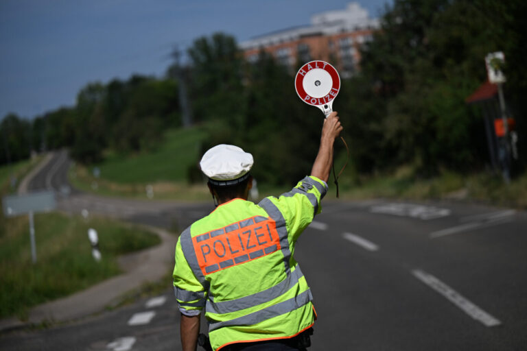Das Symbolbild zeigt einen Polizisten, der zum Anhalten auffordert.