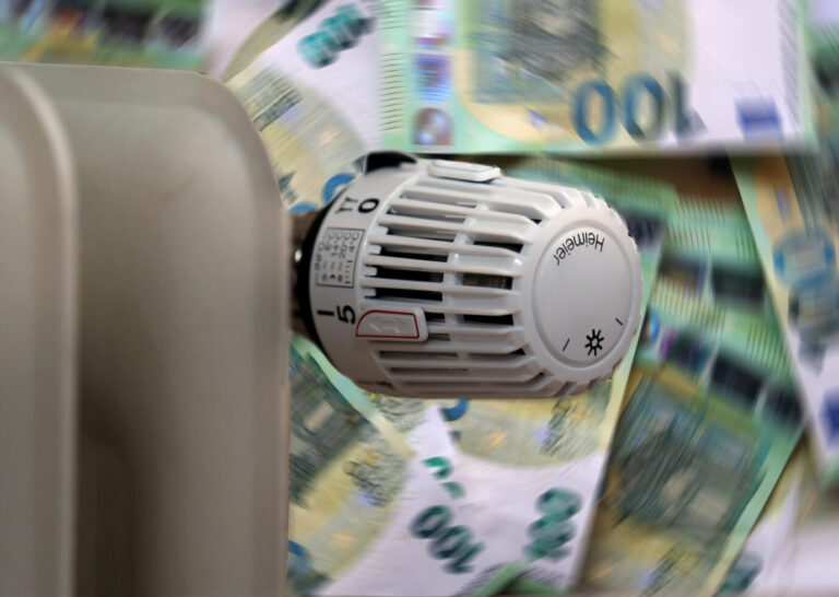 Eine Heizung mit Geldscheinen im Hintergrund. Eine Gaskrise treibt die Preise hoch.