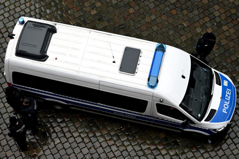 Ein Einsatzfahrzeug der Berliner Polizei steht auf nassem Kopfsteinpflaster, mehrere Beamte stehen daneben. Das Bild zeigt den Polizeieinsatz im Zusammenhang mit der Festnahme eines Syrers, der einen Anschlag in Berlin vorbereitet haben soll. Polizeifahrzeug in Berlin: Beamte nahmen am Sonnabend einen 22jährigen Syrer fest, der laut Ermittlern einen Anschlag geplant haben soll. Foto: picture alliance/dpa | Lilli Förter
