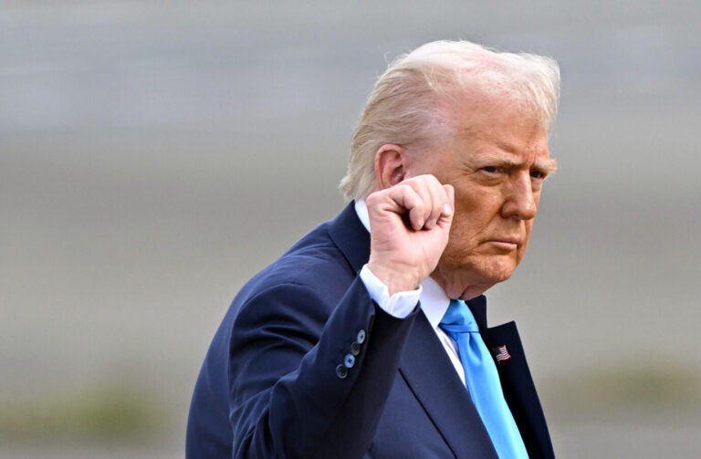 Ein Mann im dunklen Anzug hebt die rechte Faust leicht an. Er blickt ernst nach vorn. Das Bild zeigt ihn während eines offiziellen Auftritts in Washington, nachdem er Nigeria mit Konsequenzen wegen der Verfolgung von Christen gedroht hat. US-Präsident bei einem öffentlichen Auftritt in Washington: Nach eigenen Angaben will er das Pentagon auf mögliche Schritte gegen Nigeria vorbereiten. Foto: picture alliance / Jiji Press | Pool