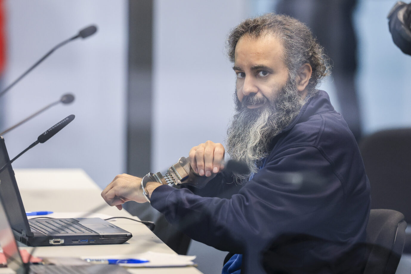 Der Angeklagte Ausländer Taleb al-Abdulmohsen sitzt mit Handfesseln in dem kugelsicheren Glaskasten Gerichtssaal im temporären Gerichtsgebäude des Landgerichtes Magdeburg. Dort beginnt am Morgen der Prozess gegen Al-Abdulmohsen. Am 20. Dezember 2024 war Taleb al-Abdulmohsen über den Magdeburger Weihnachtsmarkt gefahren. Bei dem Anschlag werden sechs Menschen getötet. Zudem wurden mehr als 300 Menschen verletzt oder traumatisiert. Die Generalstaatsanwaltschaft wirft dem Täter versuchten Mord in 338 Fällen vor.