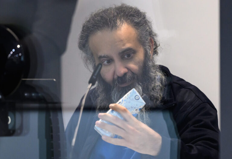 Der Angeklagte Taleb al-Abdulmohsen betrachtet vor der Fortsetzung der Verhandlung nach der Mittagspause in einem kugelsicheren Glaskasten des temporären Gerichtsgebäudes des Landgerichts Magdeburg ein Tetrapak mit Wasser. Die Generalstaatsanwaltschaft wirft dem Mann aus Saudi-Arabien versuchten Mord in 338 Fällen vor. Am 20. Dezember 2024 raste Taleb al-Abdulmohsen auf dem Magdeburger Weihnachtsmarkt in eine Menschenmenge. Fünf Frauen und ein Kind starben bei dem Anschlag, mehr als 300 Menschen wurden verletzt.