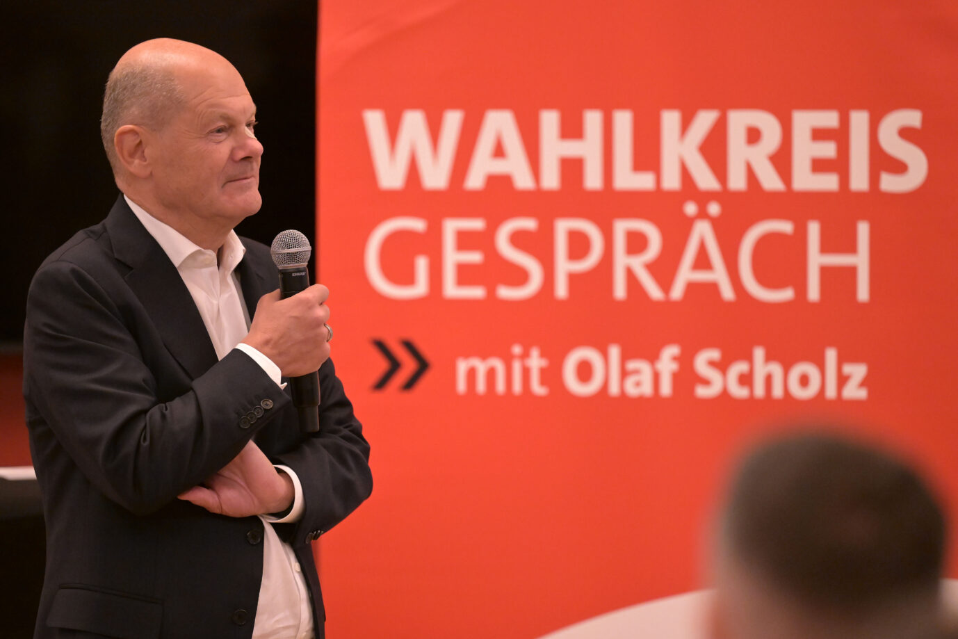 Der Brandenburger Bundestagsabgeordnete Olaf Scholz (SPD) spricht bei einem Wahlkreisgespräch zu Parteimitgliedern und Gästen. Er trägt ein Pflaster auf der Nase, nachdem er sich einen Leberfleck dort entfernen ließ. Der ehemalige Bundeskanzler ist zu Besuch im Bürgerhaus des Wahlkreises 62, den er seit der letzten Bundestagswahl mit betreut.