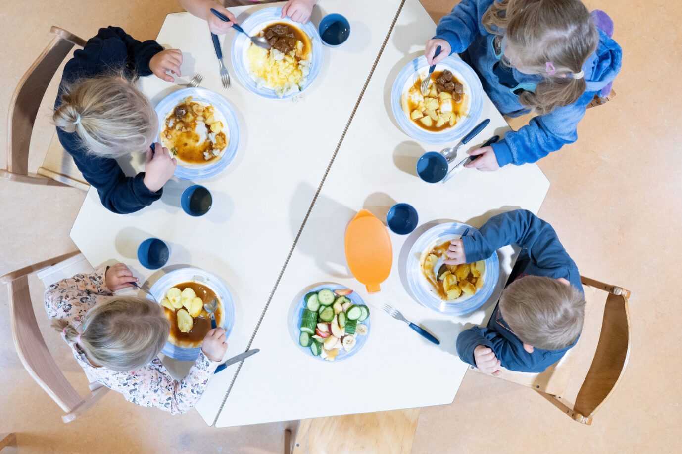Das Bild zeigt Kinder beim Essen im Kindergarten. Es ist ein Symbolbild für einen Text zu einer Dokumentation über Frühsexualisierung.