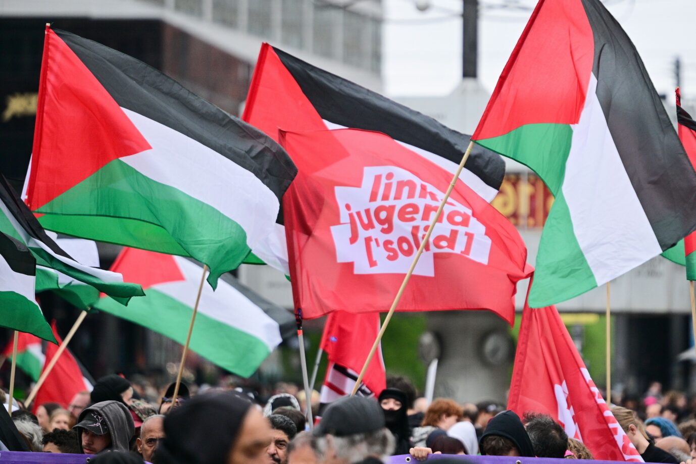 Eine Fahne der Linksjugend und Palästina-Fahnen