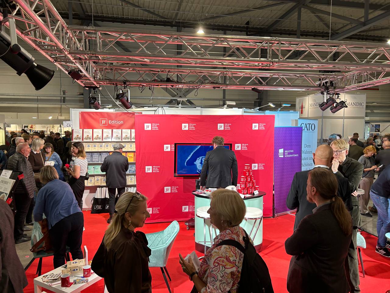 Am Stand der Jungen Freiheit sieht man einen roten Teppich, einen weißen Tisch und ein rotes Banner - es ist Seitenwechsel Buchmesse