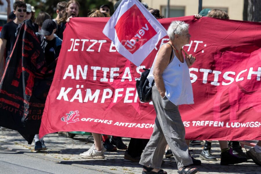 Das Bild zeigt eine alte Frau mit einer Verdi-Fahne vor einer Antifa-Demonstration. Das Grundgesetz sieht nicht vor, daß Gewerkschaften gegen Parteien agitieren.