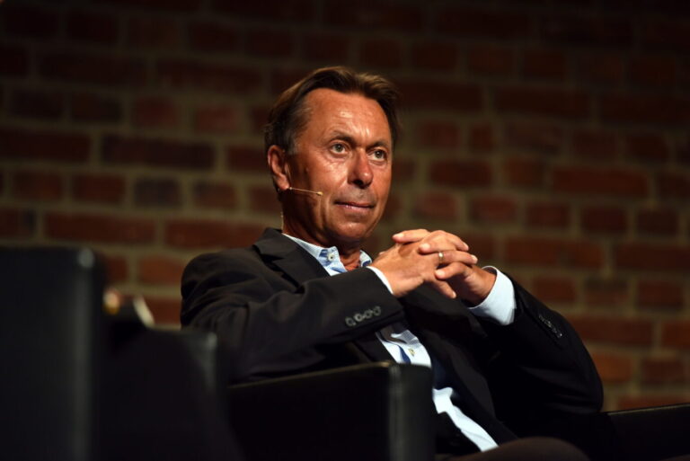 Ein Mann sitzt mit zusammengefalteten Händen und nachdenklichem Blick dar: es ist der Publizist Norbert Bolz