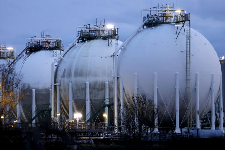 Im kalten und grauen Abendlicht stehen drei bauchige stählerne Gasspeicher in Köln-Godorf