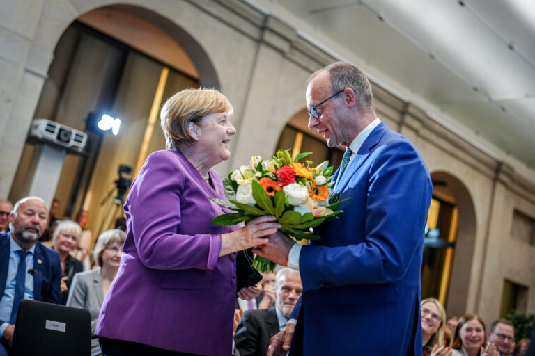 Friedrich Merz, CDU-Bundesvorsitzender und Unionsfraktionsvorsitzender, überreicht Angela Merkel beim Berliner Gespräch Spezial zum 70. Geburtstag der früheren Bundeskanzlerin einen Blumenstrauß.