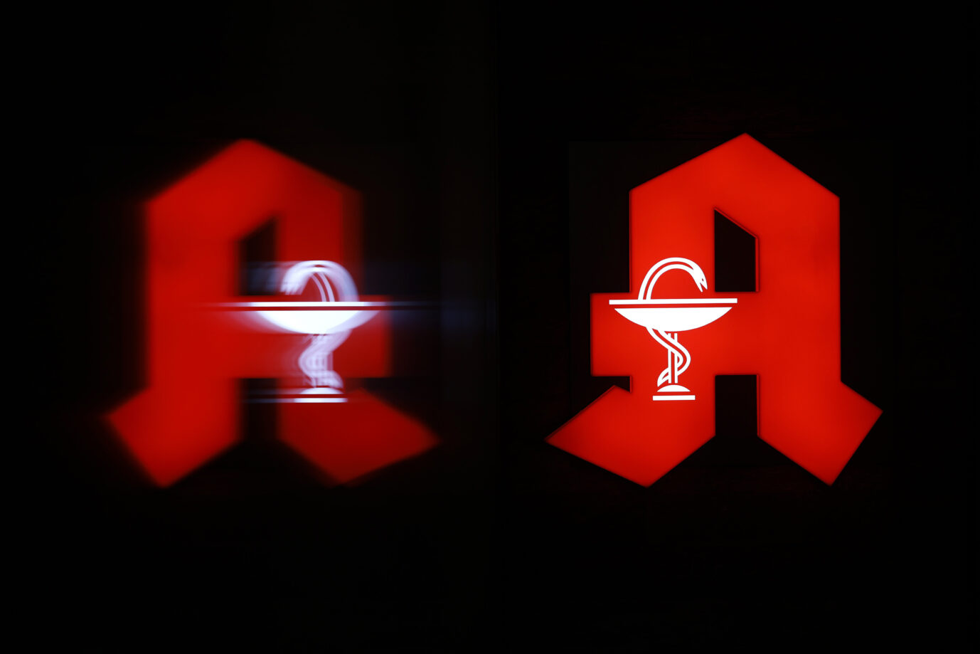 Das Logo einer Apotheke spiegelt sich nachts in der Schaufensterscheibe. In Deutschland gibt es immer weniger Apotheken. Seit Jahresbeginn mussten 384 Apotheken schließen. Für Patienten heißt das oft weitere Wege für Medikamente. (Themenbild, Symbolbild) Kerpen, 05.11.2024