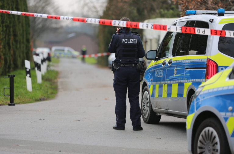Einsatzkräfte der Polizei haben nach einem Angriff in einem Wohnhaus an einem Grundstück eine Absperrung eingerichtet. Die Tat ereignete sich in Verl.