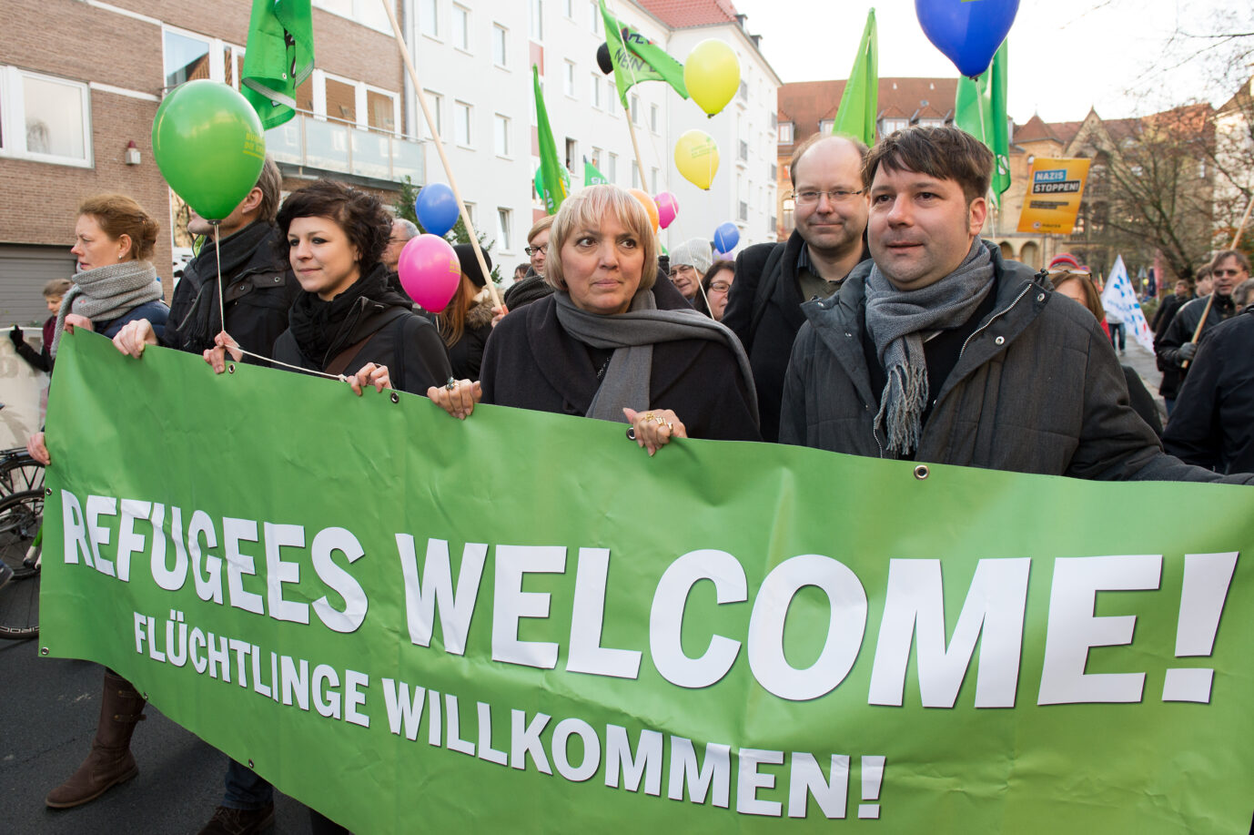 Claudia Roth (M), Niedersachsens Landwirtschaftsminister Christian Meyer (2.v.r.) und der grüne Landesvorsitzende in Niedersachsen, Stefan Körner (r, alle Bündnis 90/Die Grünen), gehen am 28.11.2015 bei einer Gegendemonstration des Bündnisses "Bunt statt Braun" zum 4. Bundesparteitag der Alternative für Deutschland (AfD) in Hannover (Niedersachsen) mit einem Transparent mit der Aufschrift "Refugees welcome, Flüchtlinge willkommen". Foto: Swen Pförtner/dpa