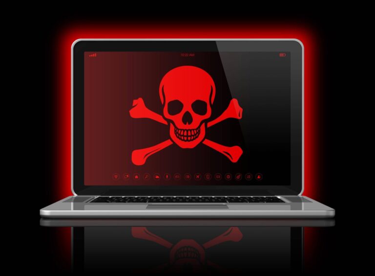Laptop mit einer Piratenflagge auf dem Bildschirm. Die moderne Seeräuberei heißt Industriespionage.