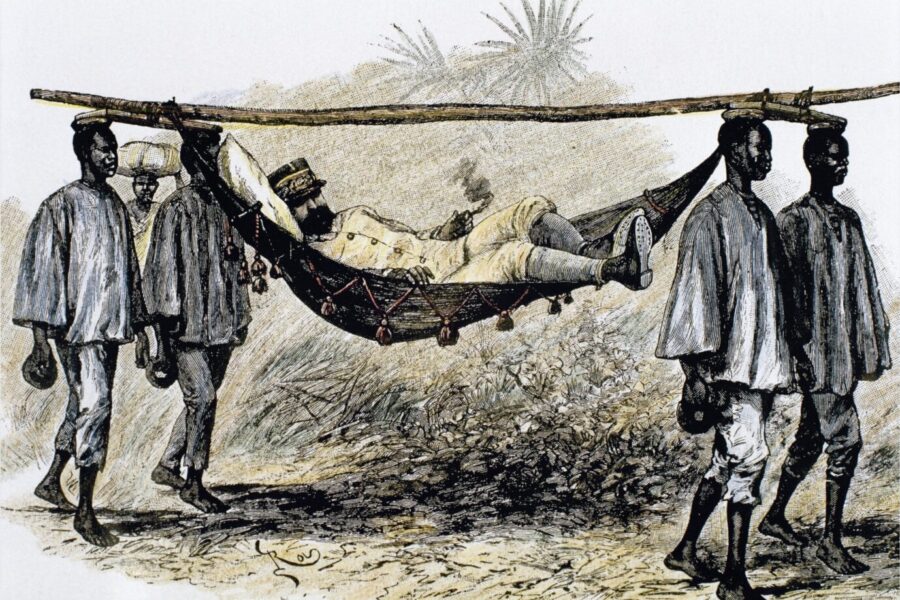 So sieht Mausfeld den Westen: Als einen weißen Kolonialherren, der sich von unterdrückten schwarzen Sklaven in einer Sänfte tragen läßt