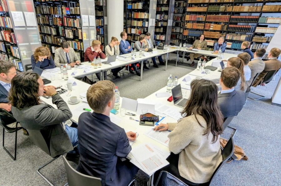 Um ein Viereck aus Tischen herum sitzen junge Menschen und haben Bücher vor sich liegen – es handelt sich um eine Szene aus dem 6. Jungkonservativen Seminar in der Bibliothek des Konservatismus